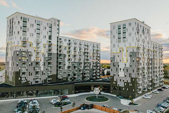 Two identical buildings with a parking lot in front of them.