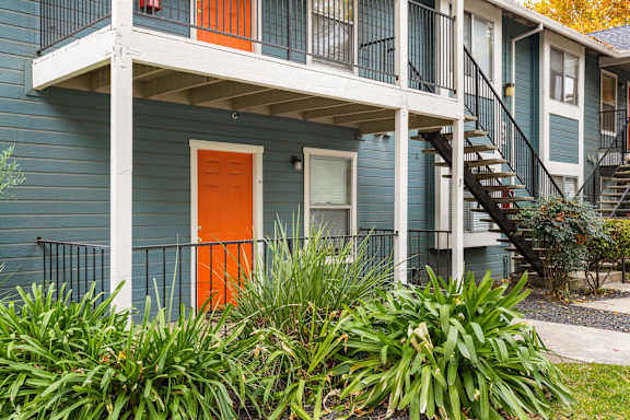 A blue house with an orange door and a white porch.at Redwood Cove Apartments, California, 95928