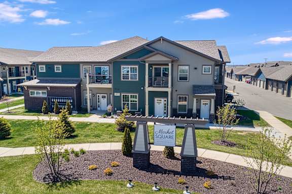 a large house with a sign in front of it on a sidewalk