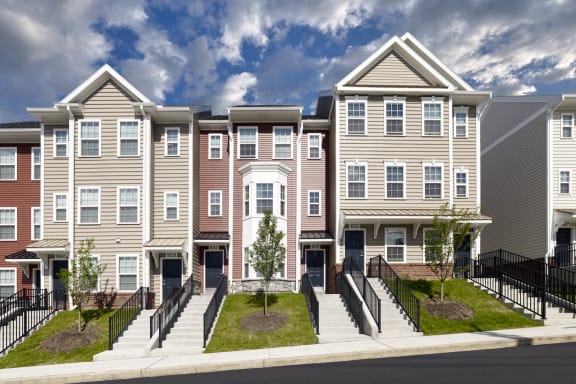 a rendering of a row of townhomes with a blue sky in the background