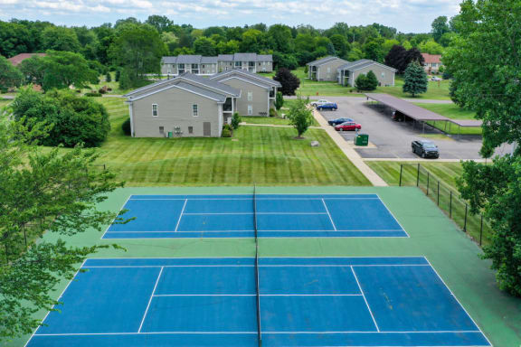 an aerial view of a tennis court with houses in the background