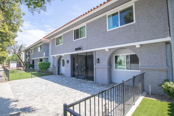 an apartment building with a walkway and a gate