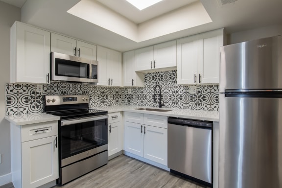 a kitchen with stainless steel appliances and white cabinets