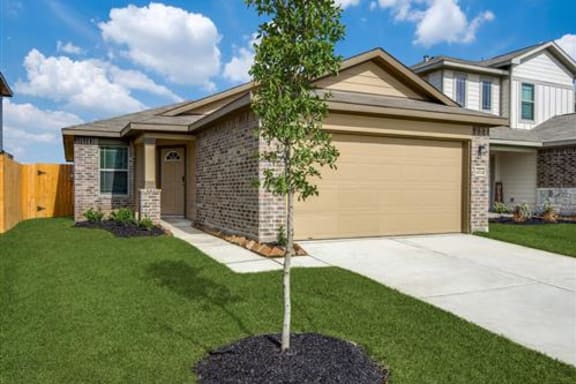 a house with a tree in the front yard at The Village at Caney Mills, Conroe, 77303