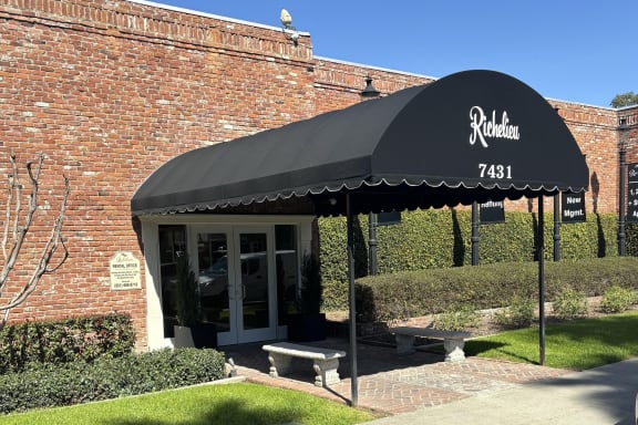 awning in front of a brick building with a bench