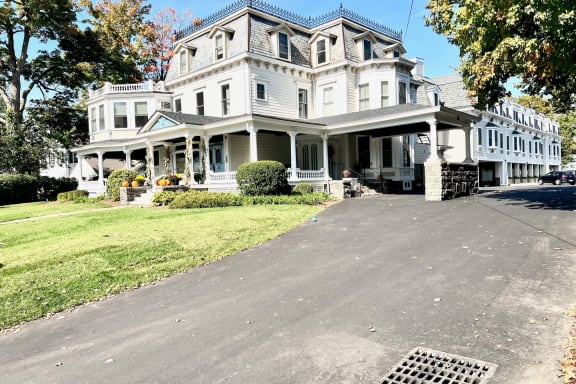 a large white house with a driveway in front of it