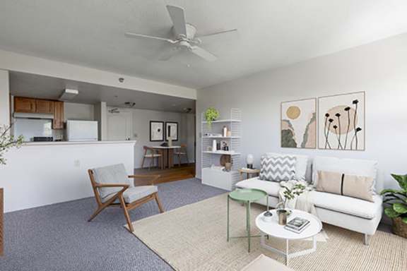 A living room with a white couch, a green coffee table, and a painting on the wall.