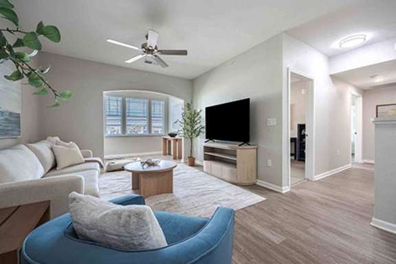 A living room with a blue chair and a white couch.