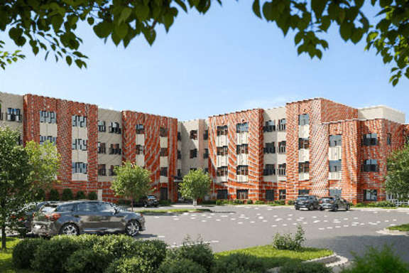 A large red brick building with a parking lot in front.