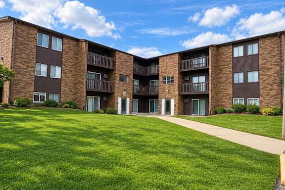 Apartment complex with a green lawn in front.