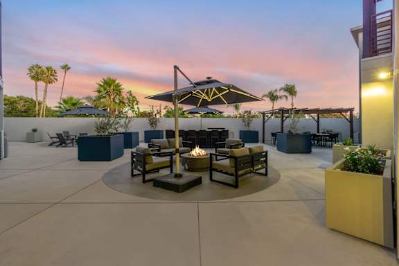 A patio with a table and chairs under an umbrella.