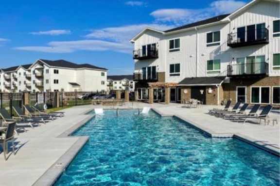 A swimming pool in front of apartment buildings.