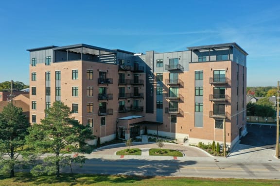 a brick apartment building with balconies and a sidewalk