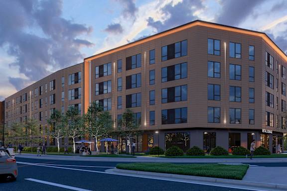 A modern apartment building with a parking lot in front.at The Rosalyn | Affordable 55+ Apartments in Bloomington, Bloominton, MN 55420