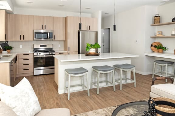a kitchen with a large island with three stools