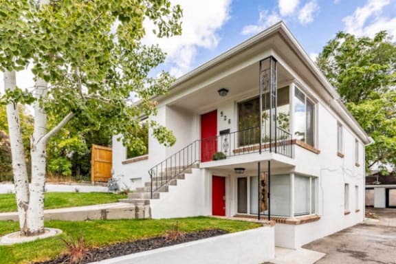 a white house with a red door and a driveway