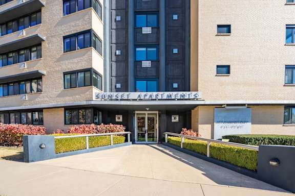 The image shows the front of a building named Sunset Apartments.
