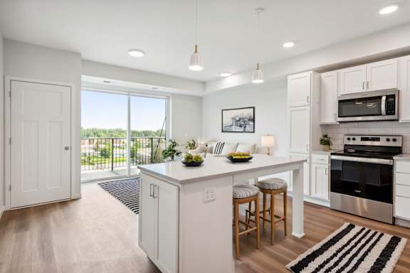 A modern kitchen with white cabinets and stainless steel appliances.