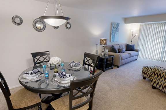 A dining room with a round table set for four.