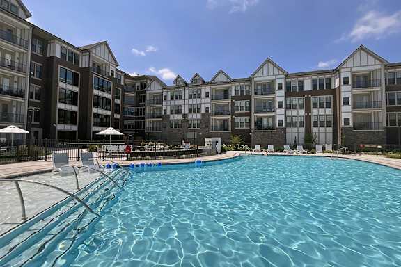 A large swimming pool in front of apartment buildings.