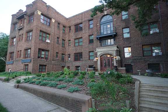 A large red brick building with a green lawn in front.