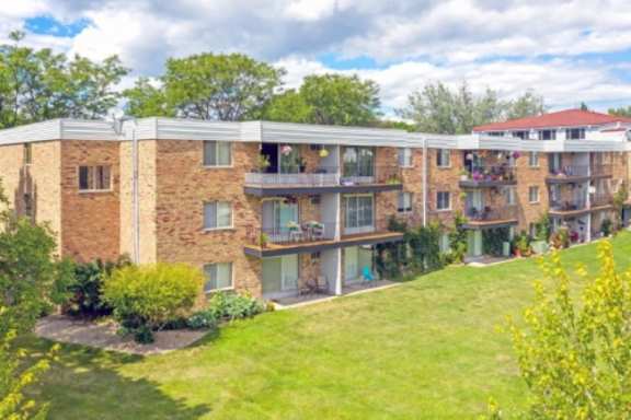 Apartment building with green lawn in front.