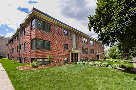 A red brick building with a green lawn in front.