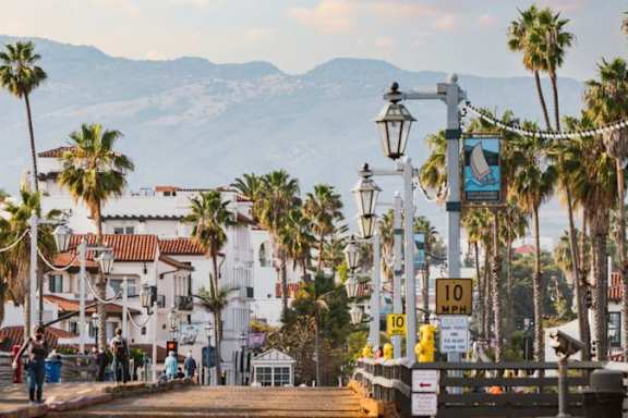 A street scene with palm trees and a sign that reads "10 MPH".