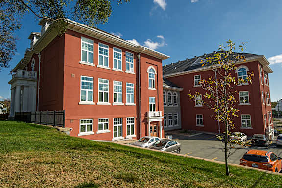 A red building with a tree in front of it.