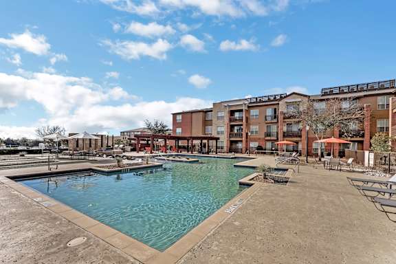 A large swimming pool in front of apartment buildings.