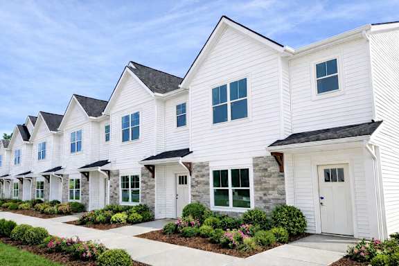 A row of white houses with green windows and doors at Ventura Townhouses, West Olive  , Michigan