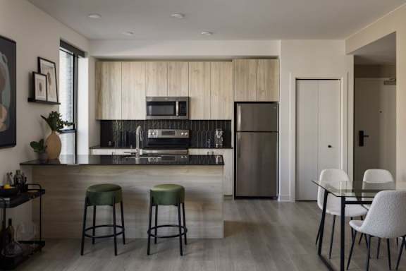 A modern kitchen with a bar area and a dining table.