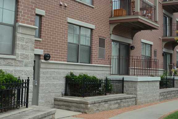 A brick building with a black fence in front.