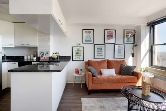 A modern kitchen with a black countertop and white cabinets.