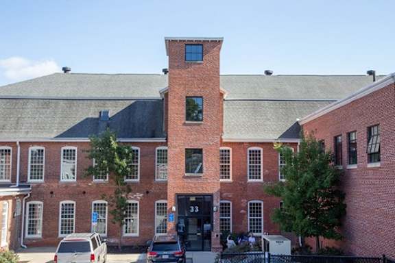 A red brick building with a black gate in front.