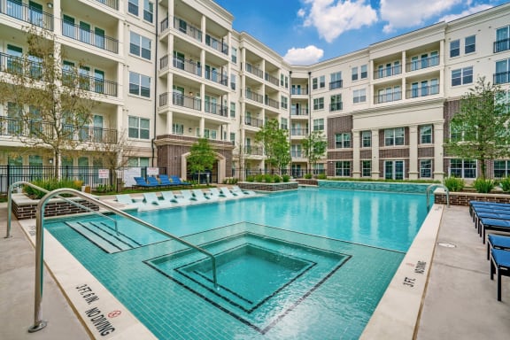 Luxurious swimming pool area with lounge seating at Epoch on Eagle apartments in Denton, TX