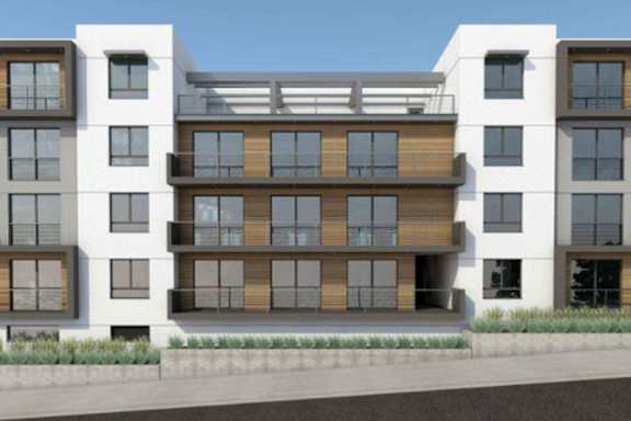 A modern apartment building with balconies and a mix of wood and glass exterior.