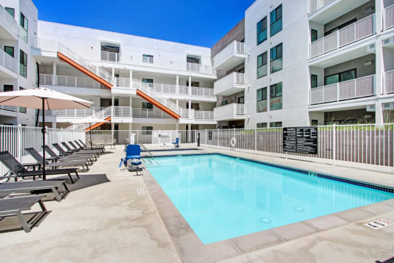 a swimming pool in front of an apartment building with a pool