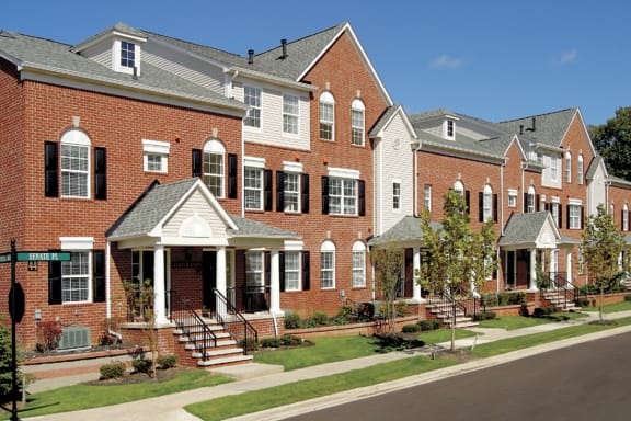 a row of brick and white houses on the side of a street