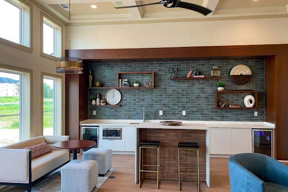 A kitchen with a blue chair and a white sofa.