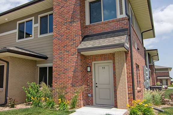a brick house with a white door and a sidewalk