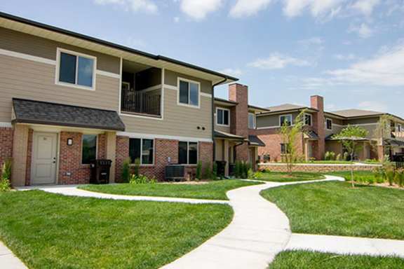 a sidewalk in front of a row of houses