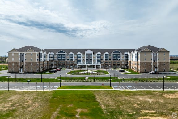 an exterior view of an apartment building with a parking lot