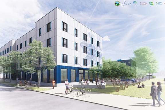 A modern building with a blue door and windows is surrounded by trees and people walking.