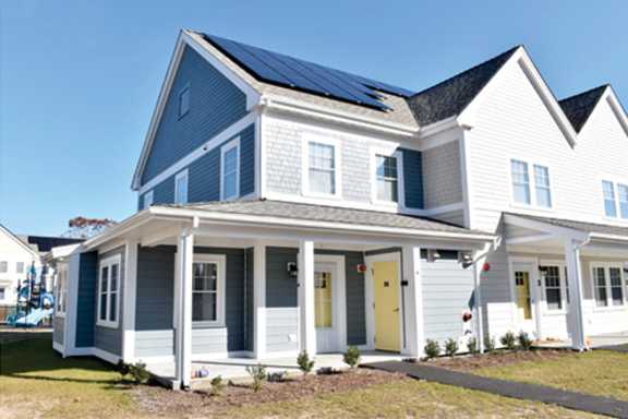 a white house with solar panels on the roof