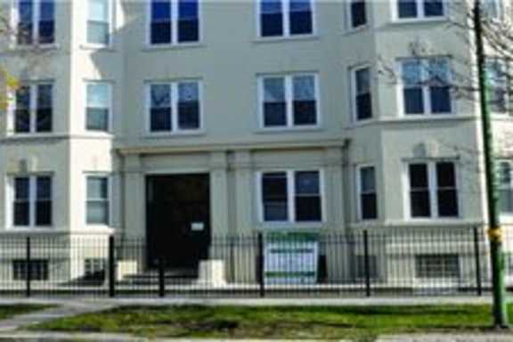 a white building with a black fence in front of it