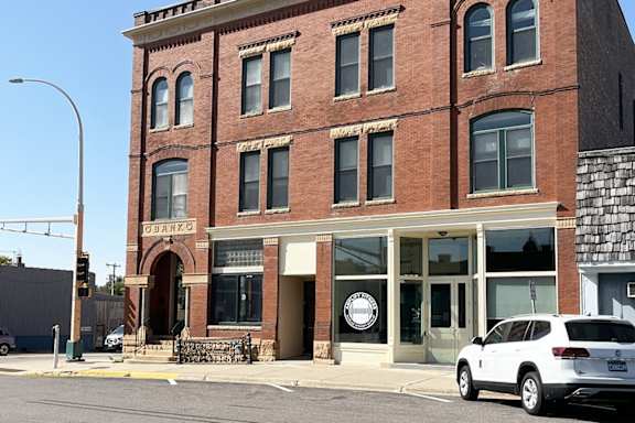 a red brick building with a white car parked in front
