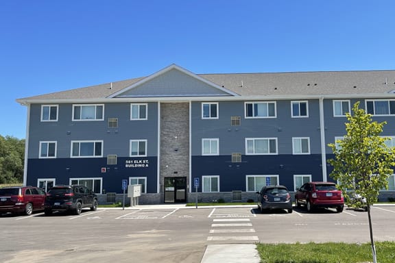 a large blue building with cars parked in front of it