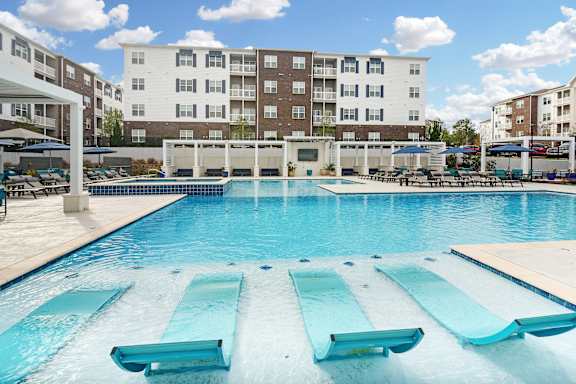 a large swimming pool with a building in the background