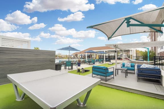 a rooftop patio with tables and chairs and umbrellas at The Met Apartment Homes, Hattiesburg, MS, 39402